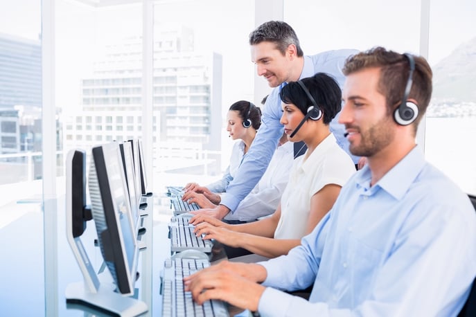 Side view of manager and executives with headsets using computers in the office